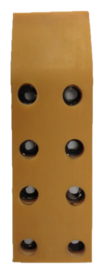 Pieza rectangular de goma de color ámbar con ocho agujeros pasantes en dos filas