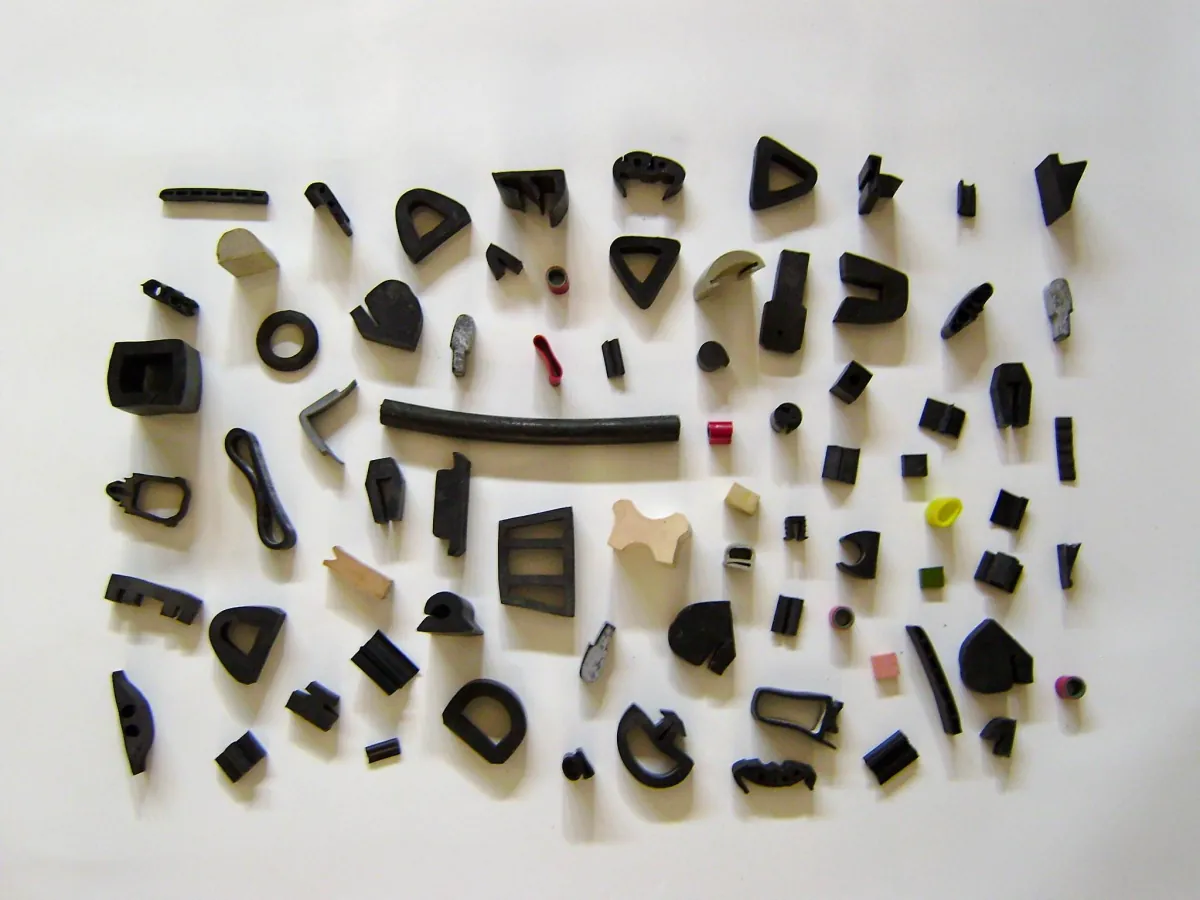 Muestrario de piezas, perfiles y juntas de goma de distintas formas y colores sobre fondo blanco